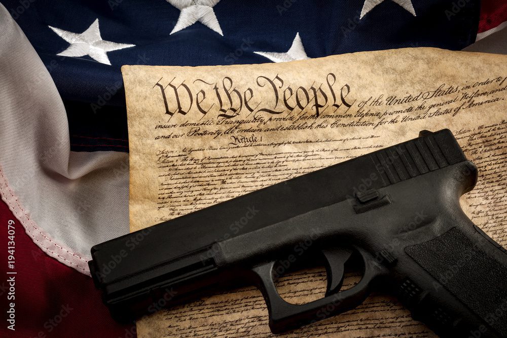 A gun laying on the Constitution and American flag, symbolizing Record Eraser reinstating your gun rights.