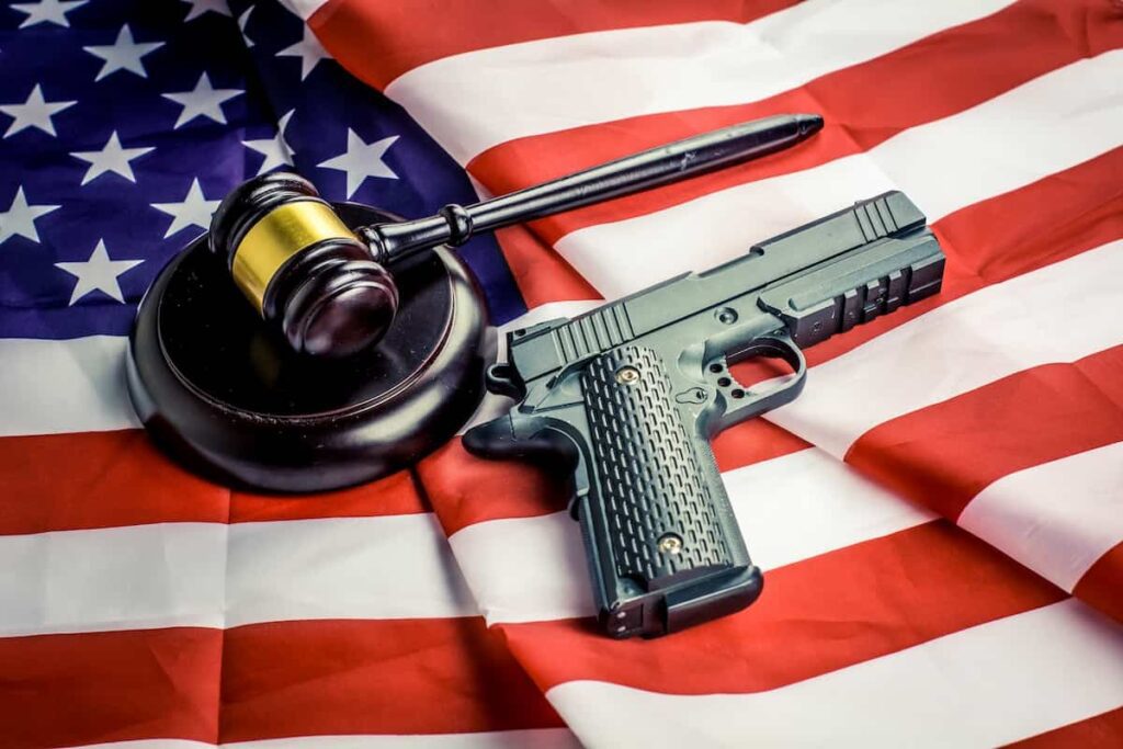 A gun and a gavel sitting on top of the American flag, which represents Record Eraser and their commitment to getting your gun rights restored in PA.